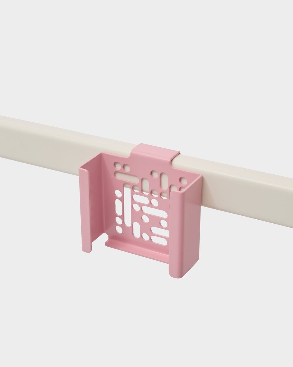 Bubble Gum pink Apple TV 4K Mount clipped onto a cream desk rail in a studio packshot, angled side view