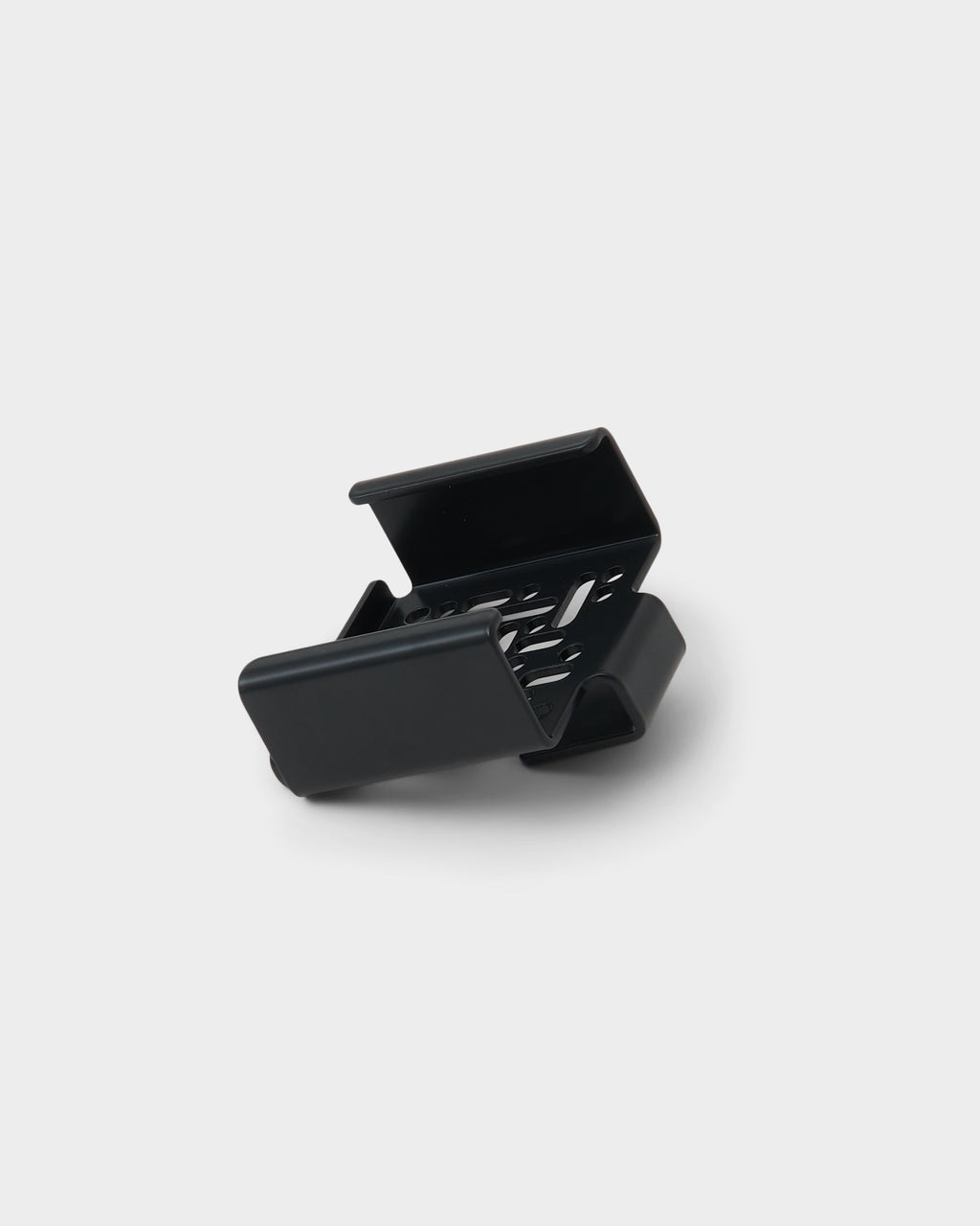 Apple TV 4K Mount in Oat shown from a rear angle in studio, revealing vented cradle and folded metal bracket arms
