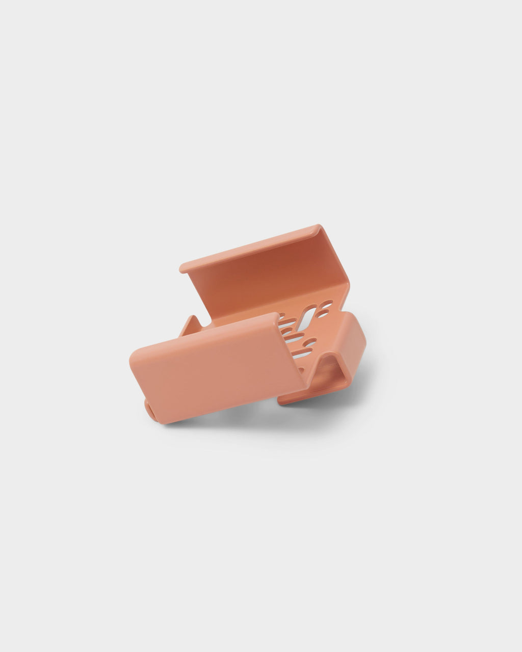 Dusty Rose Apple TV Mount shown open at an angle in a studio packshot, revealing vented interior clamp arms