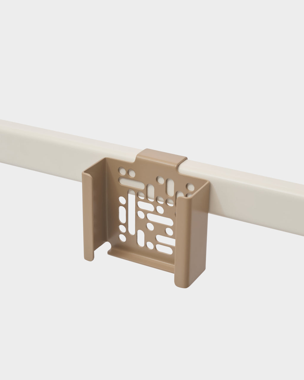 Sandstorm Apple TV Mount clipped onto a cream rail in a studio packshot, angled view showing perforated cradle