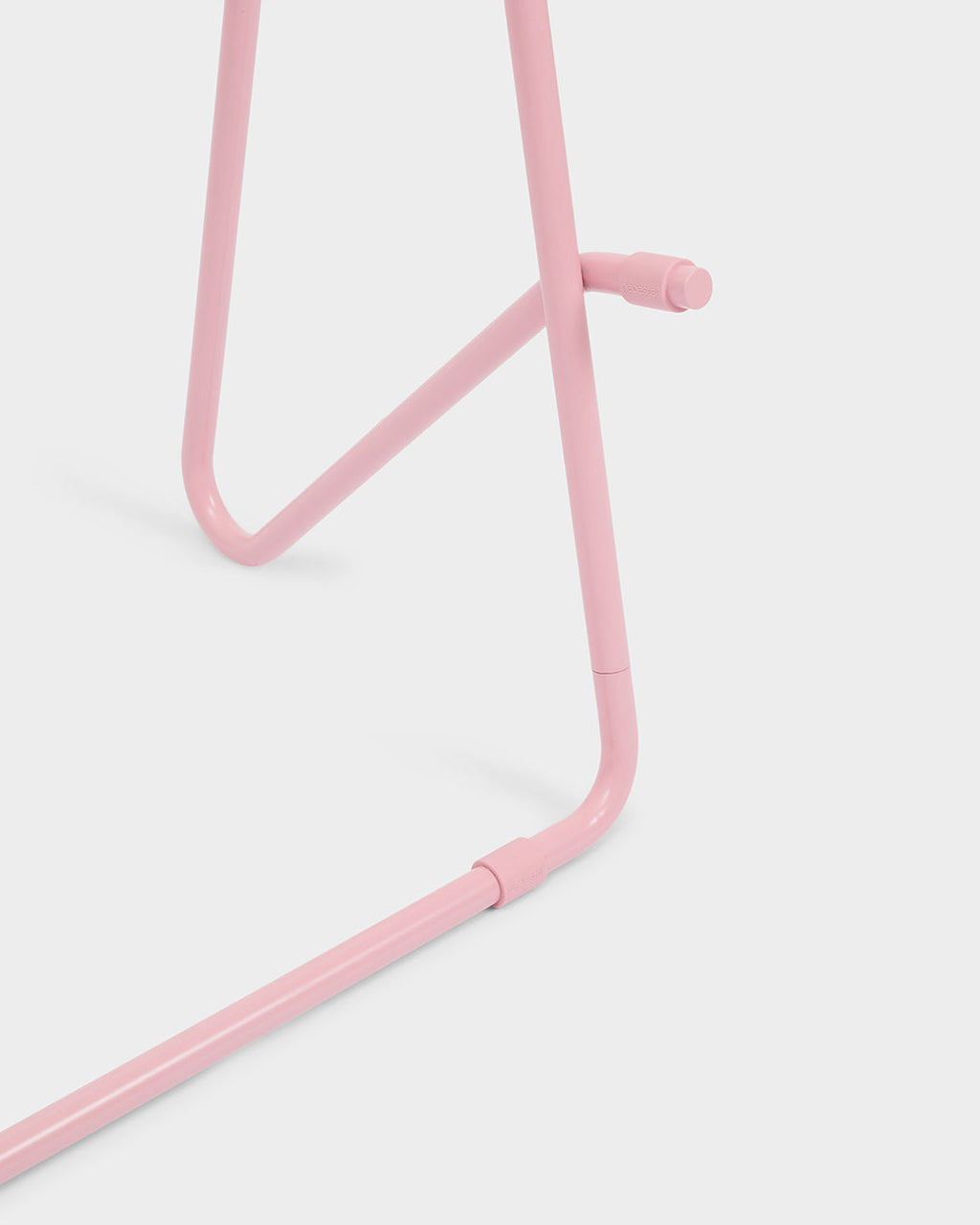 Close-up of the Bloom Stands Low in Bubble Gum pink, showing tubular steel frame joints and knob against a studio backdrop
