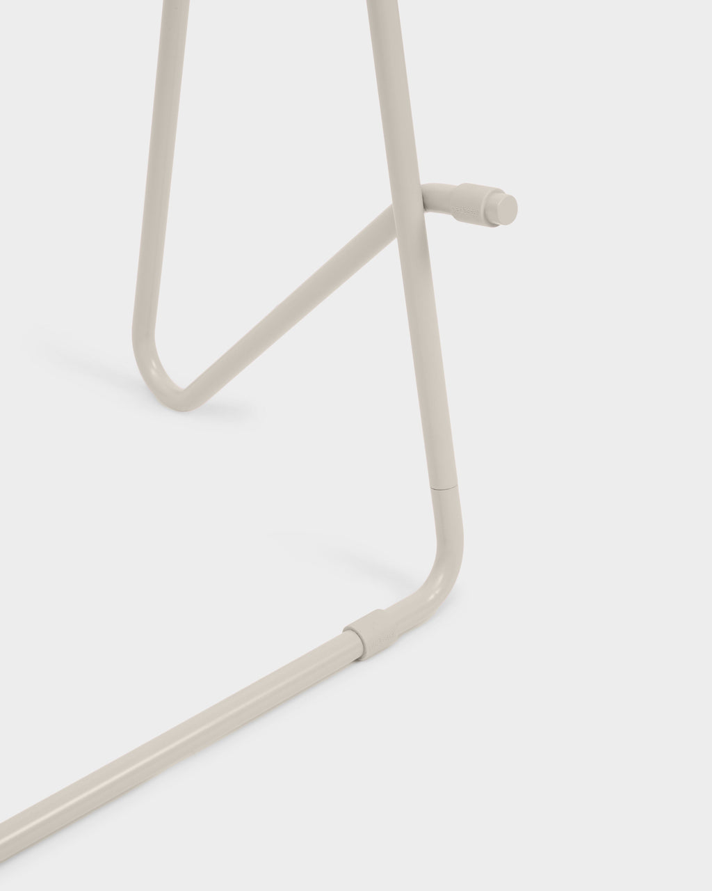 Close-up studio detail of Bloom in Oat Stands Low, showing oat-toned tubular steel legs, joint connector and branding