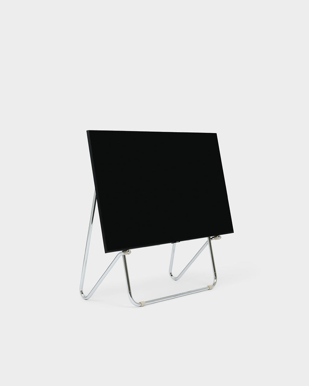 Bloom in Chrome low stand holding a black flat-screen TV at an angle, studio packshot on light grey background