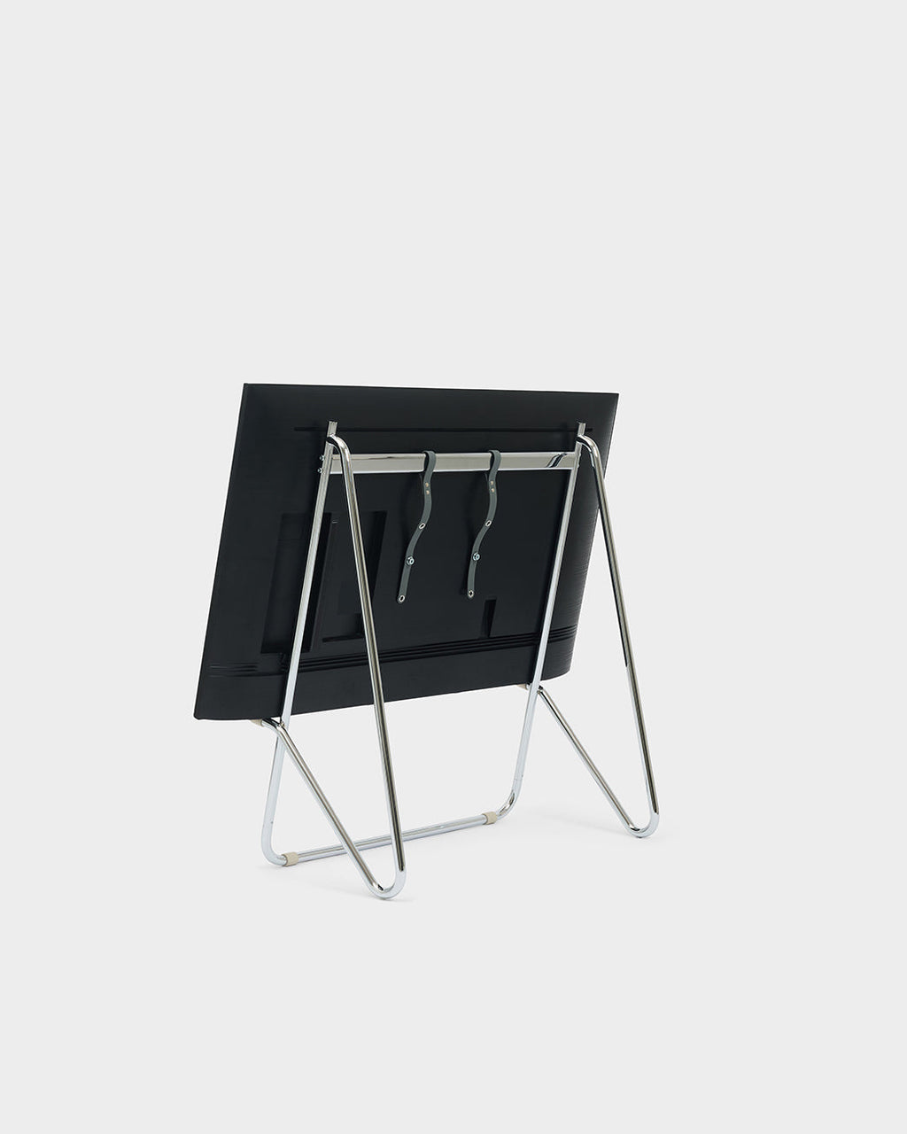 Bloom in Chrome low stand folded flat with black panel, rear three-quarter view on a light studio backdrop