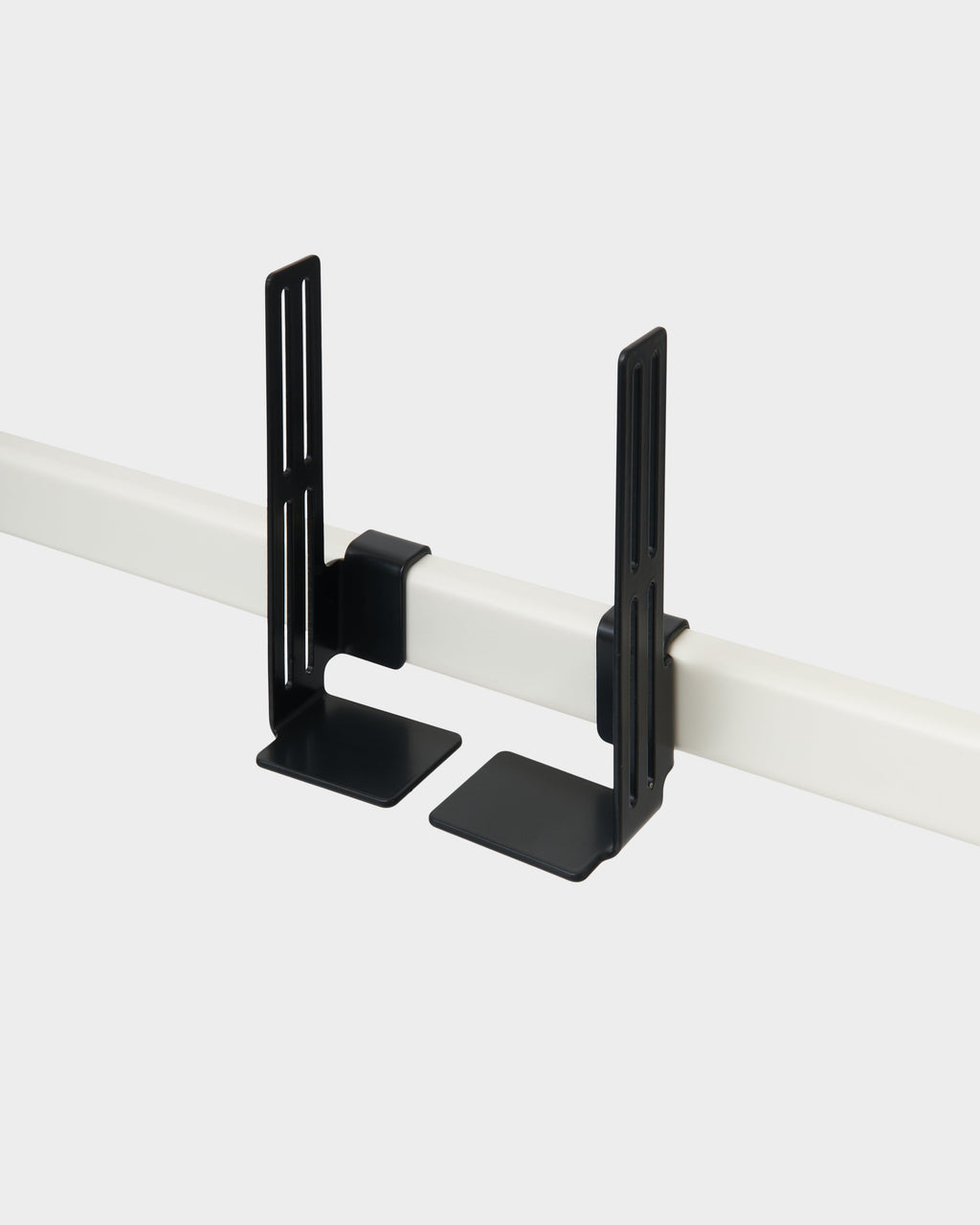 Pair of Box Mount brackets in Charcoal clipped onto a white rail, studio packshot at an angle showing slotted arms