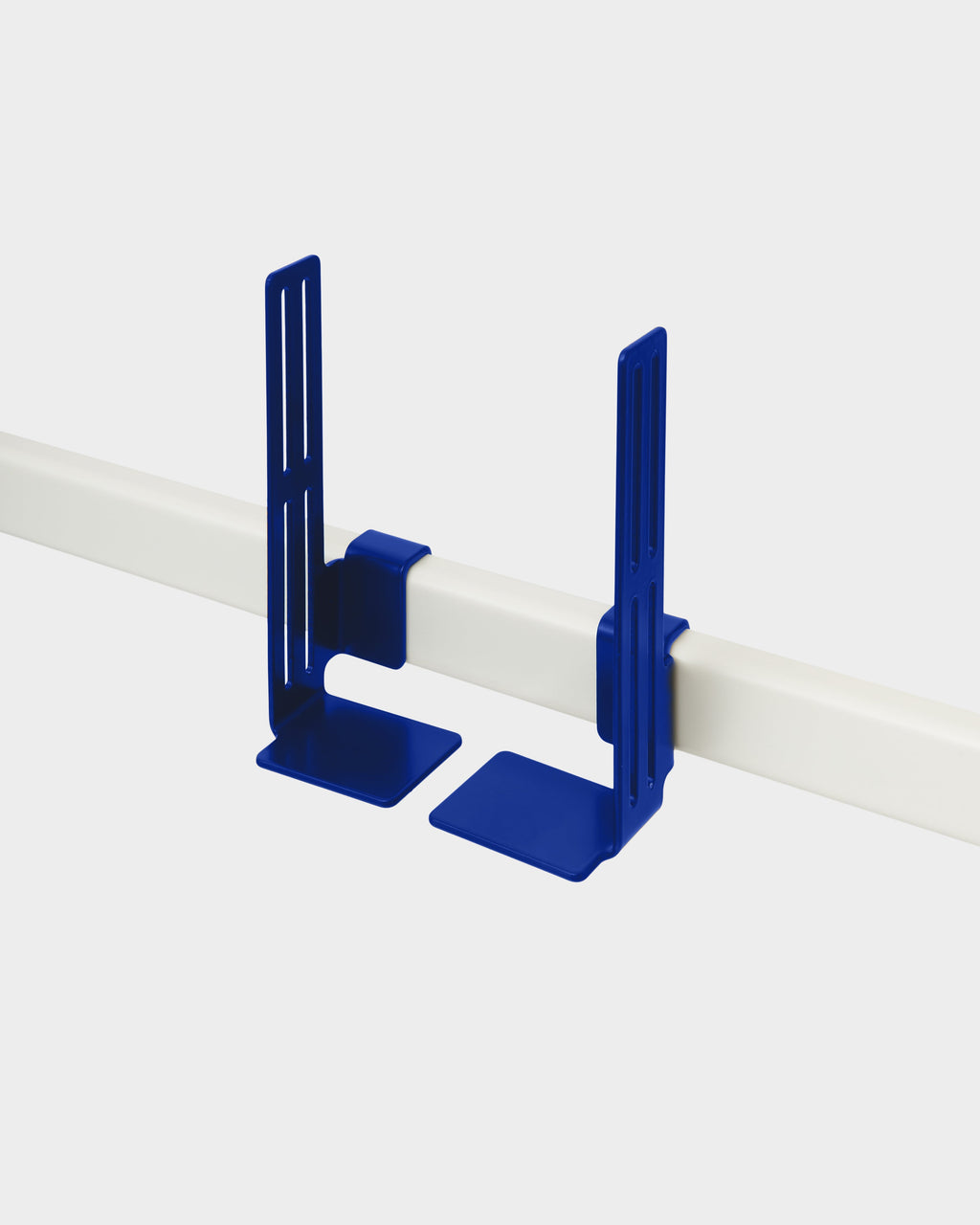 Pair of Box Mount brackets in Ultra Marine clipped onto a white rail, studio packshot at an angle