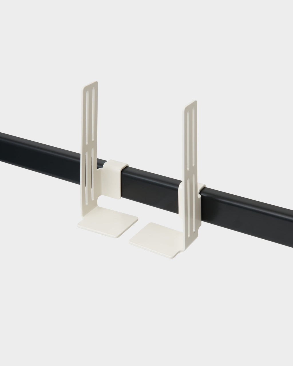Two Box Mount brackets in Pearl clipped onto a black rail, studio packshot at a three-quarter angle showing slotted arms