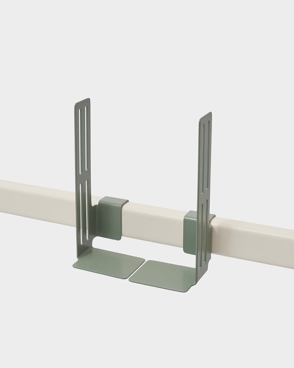 Mossy Green Box Mount clipped onto a cream rail in a studio packshot, angled view showing slotted arms and flat base