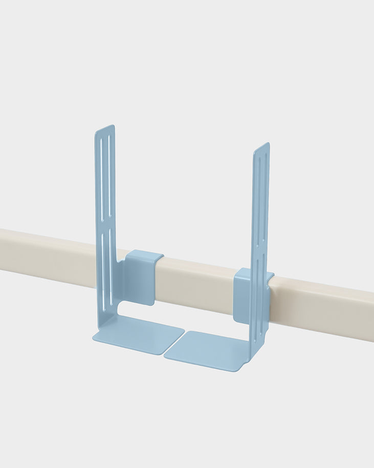 Powder Blue Box Mount clipped onto a cream rail in a studio packshot, angled view showing slotted brackets and base