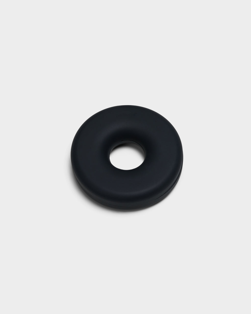 Charcoal Cable Bagel cable manager, studio packshot at a three-quarter angle showing its smooth matte donut form