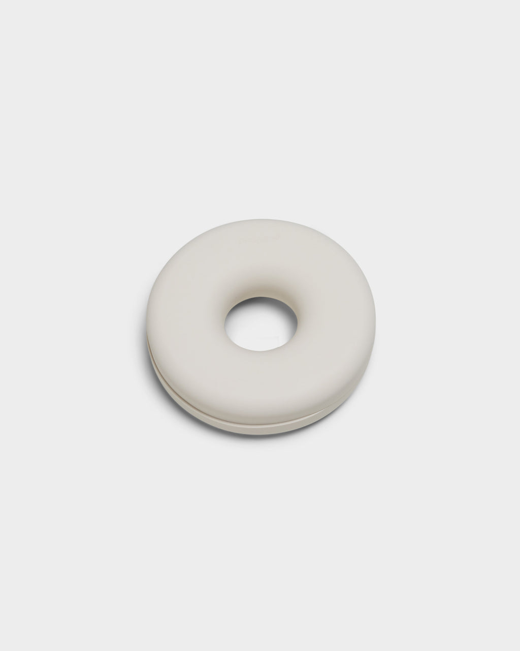 Cable Bagel in Pearl, a donut-shaped silicone cable manager shown closed at a slight angle in a studio packshot