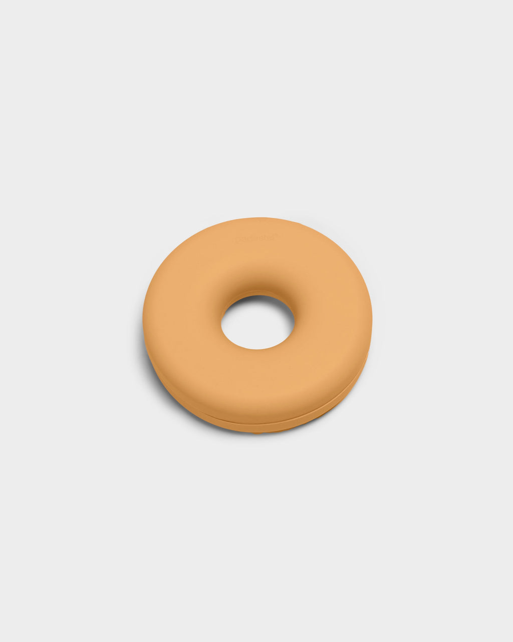 Apricot Cable Bagel cable manager shown at a slight angle in a studio packshot, matte donut-shaped silicone ring