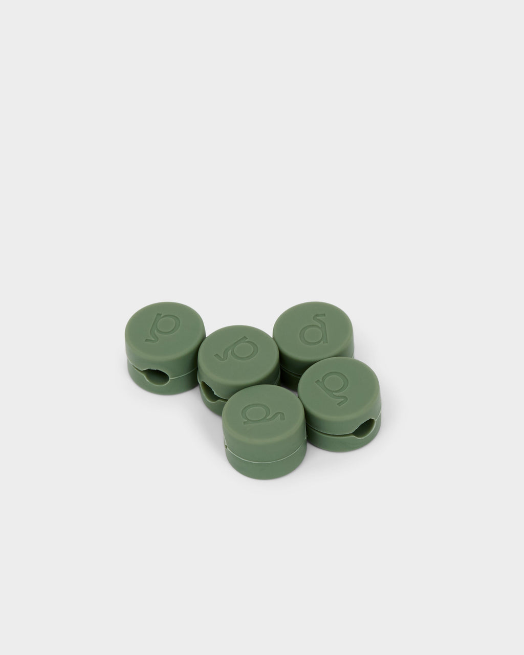 Five round Cable Clips in Mossy Green clustered on a white studio backdrop, shown at an angle with logo embossing