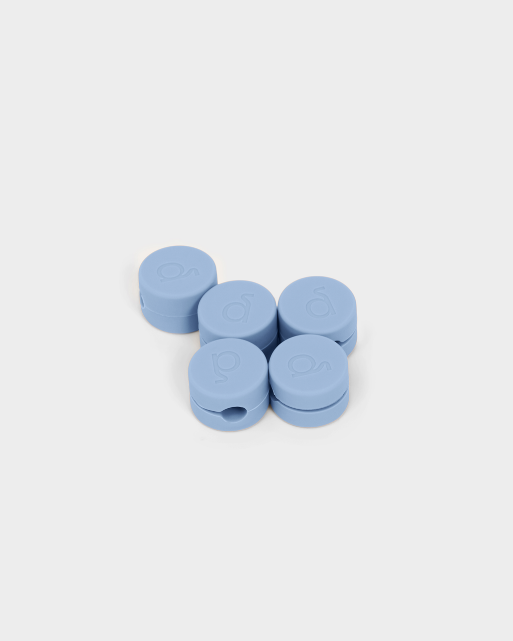 Five round Powder Blue cable clips arranged in a cluster on a light grey studio background, shown at an angle