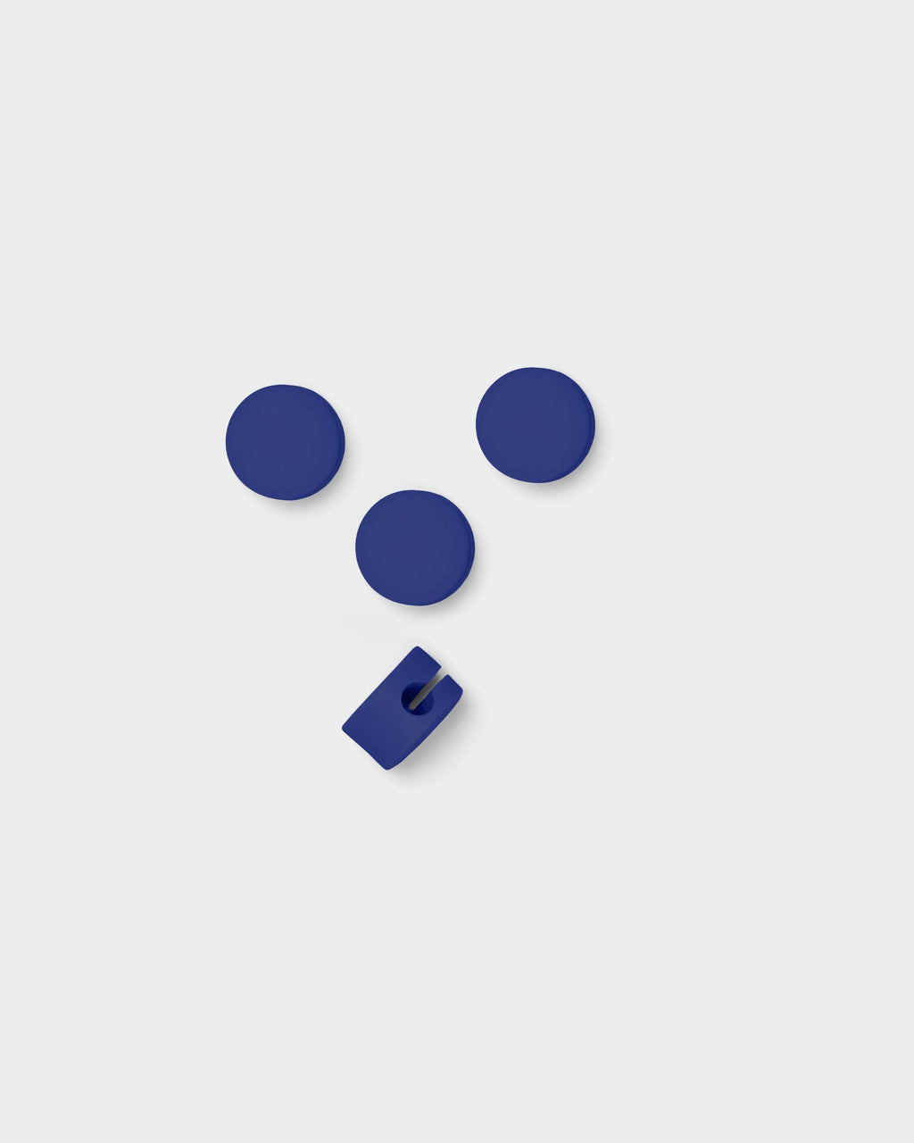 Three round Cable Dots in Ultra Marine with one slotted cable holder, overhead studio packshot on light grey