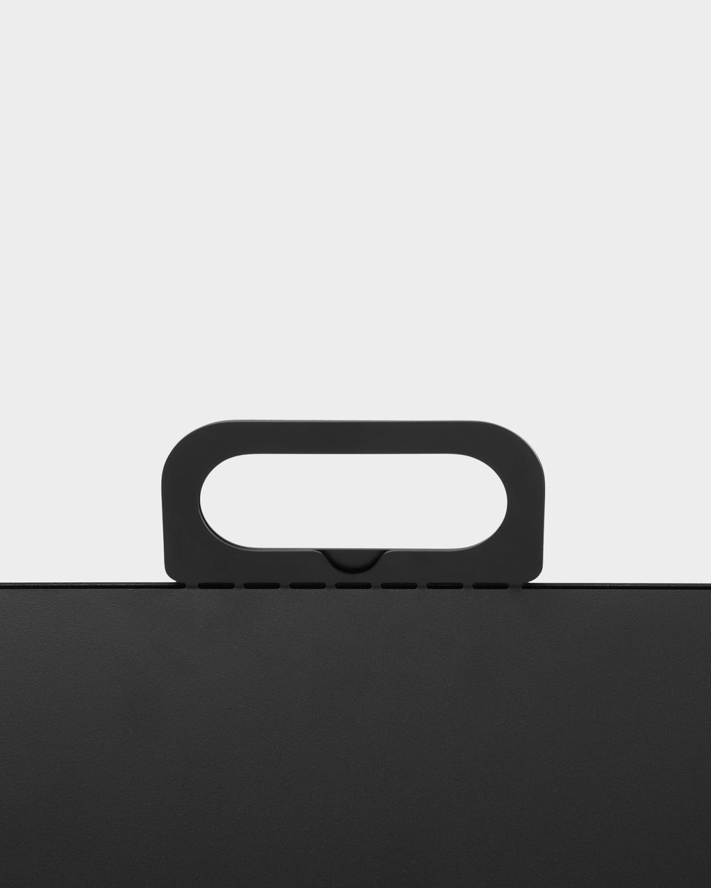 Close-up studio detail of the Cable House in Charcoal, showing its rounded carry handle and slotted top edge