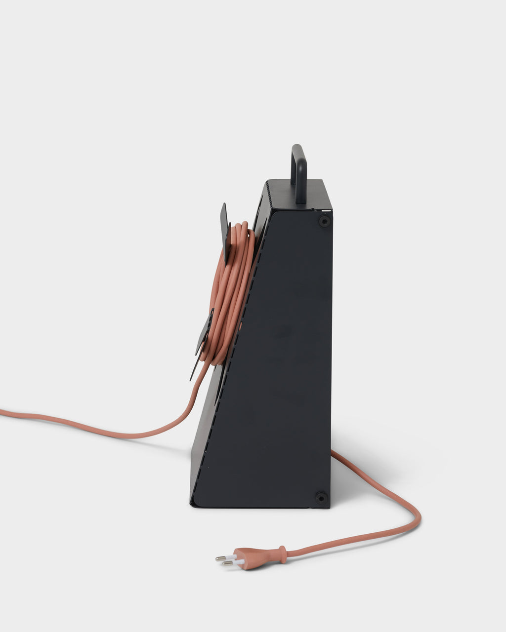 Side profile studio shot of the Cable Stand in Charcoal with terracotta cord wrapped inside and plug trailing out front