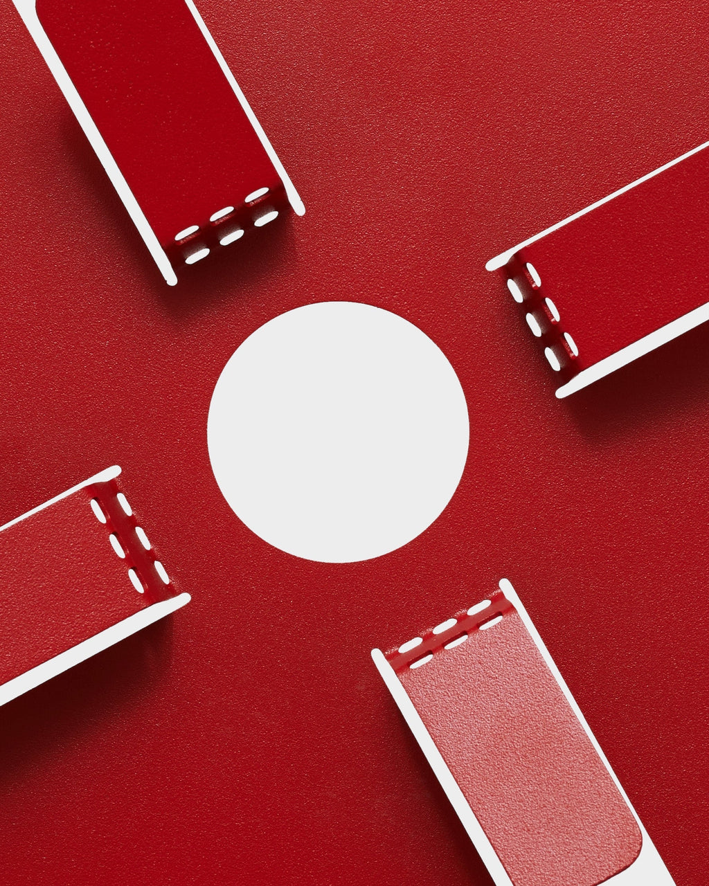Four Fire Red Cable Stand units arranged around a white circle on a red studio backdrop, overhead view