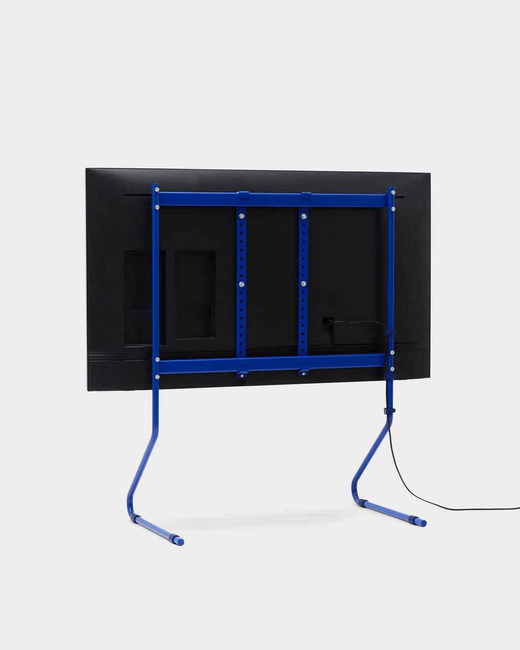 Ultra Marine cable ties routing a power cord along a blue TV stand's leg, rear studio view with mounted flat screen