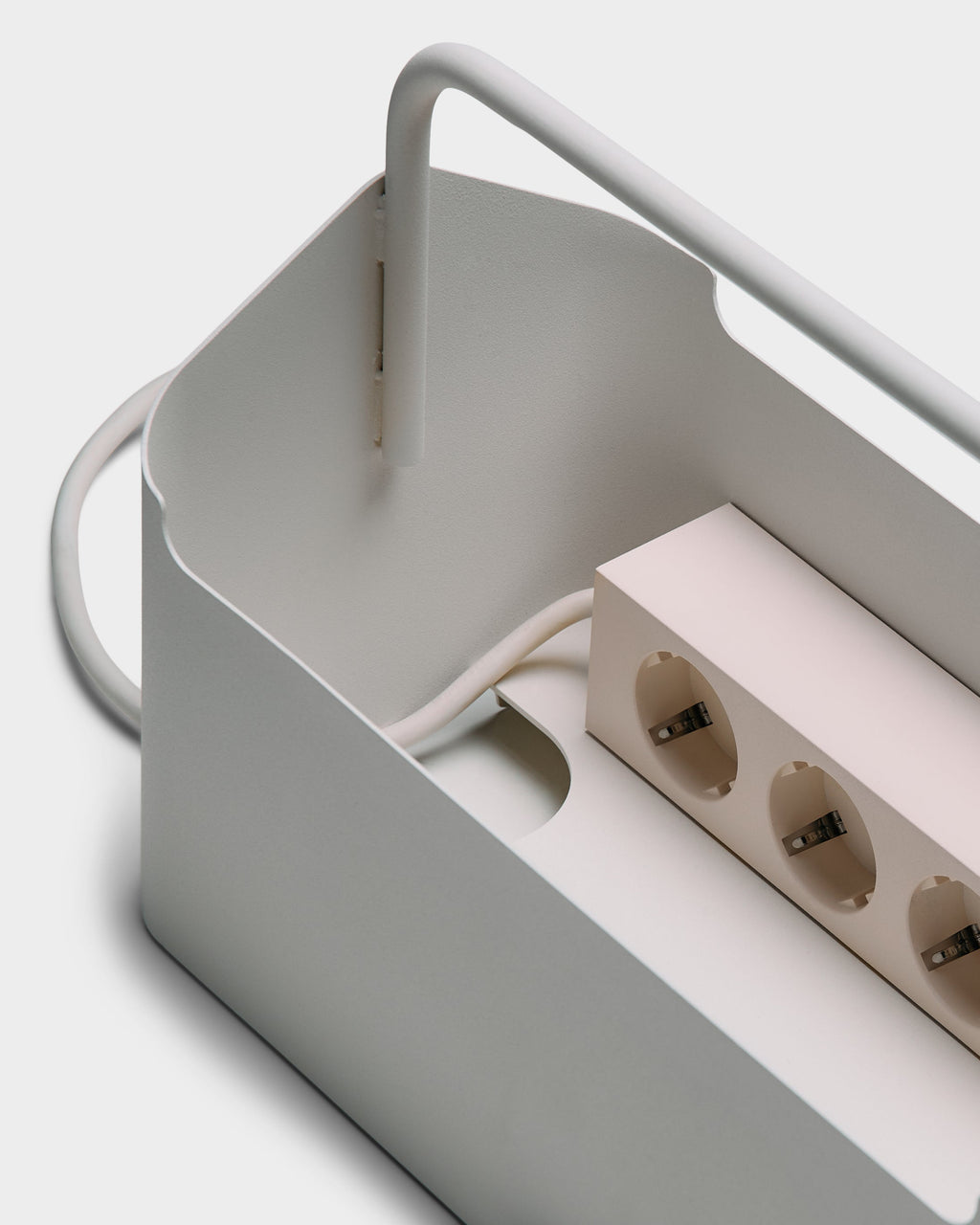 Close-up studio detail of Cable Villa in Pearl showing carry handle, cable slot and power strip inside the metal box