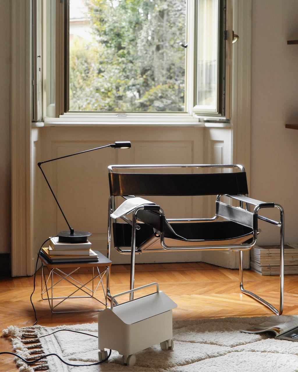 Pearl Cable Villa on castors hides cords beside a Wassily chair and lamp in a sunlit parquet room