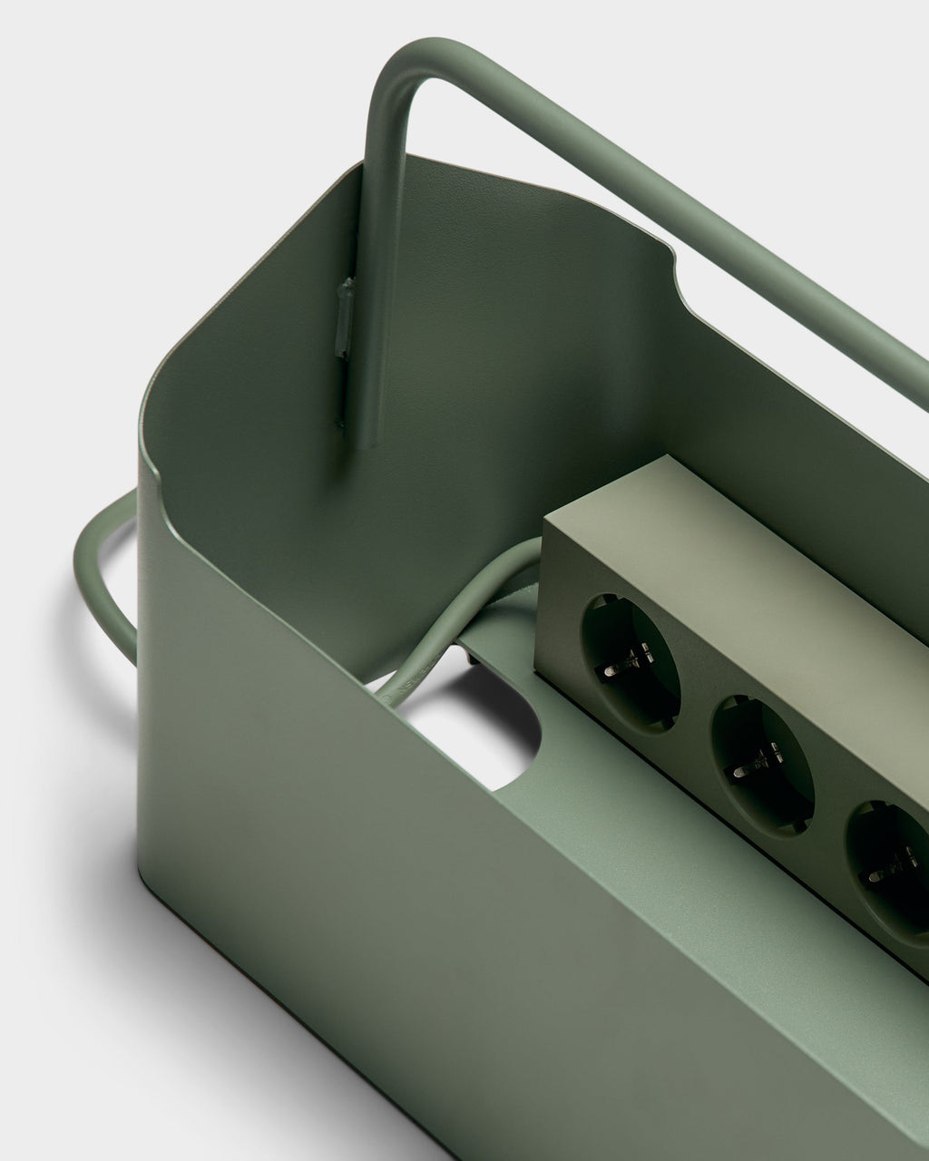 Close-up angled studio shot of the Cable Villa in Mossy Green, showing power strip sockets, coiled cord and carry handle