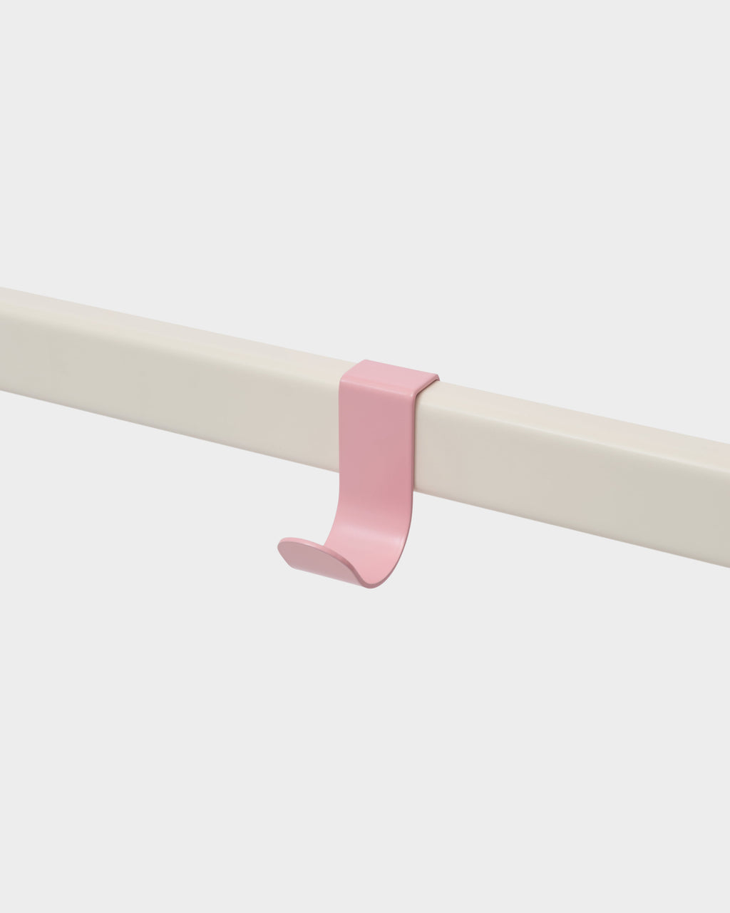 Bubble Gum pink Hook Mount clipped onto a cream rail, studio packshot angled view showing its curved J-shape profile