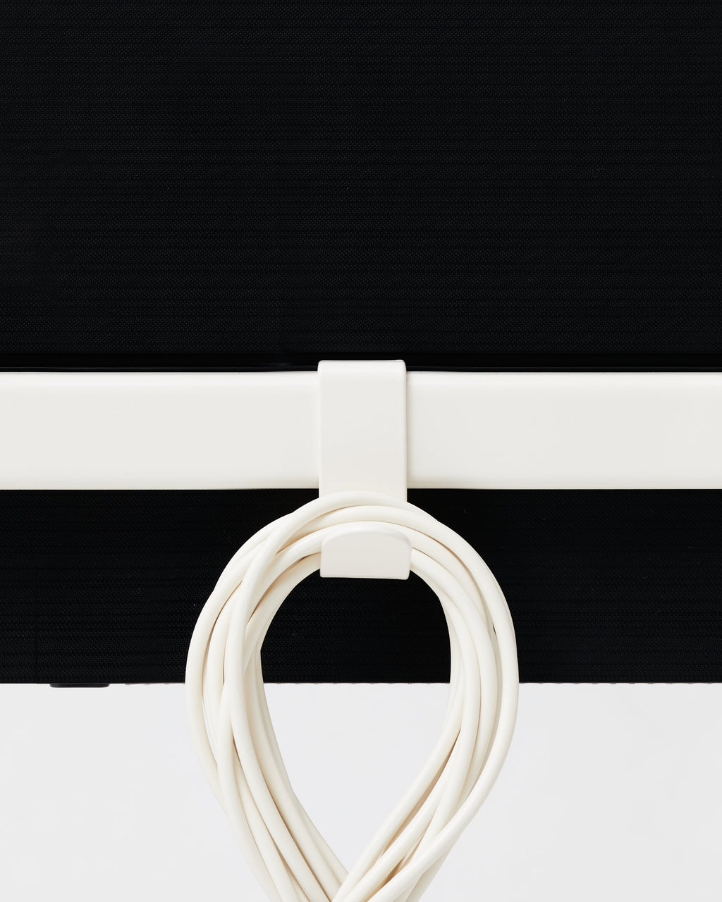 Hook Mount in Mossy Green clipped to a rail, close-up studio shot with a coiled white cable hung on the hook