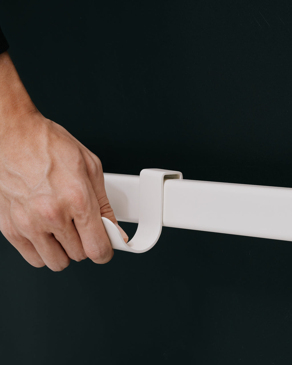 Hand sliding the Powder Blue Hook Mount onto a white rail, close-up studio shot against dark backdrop