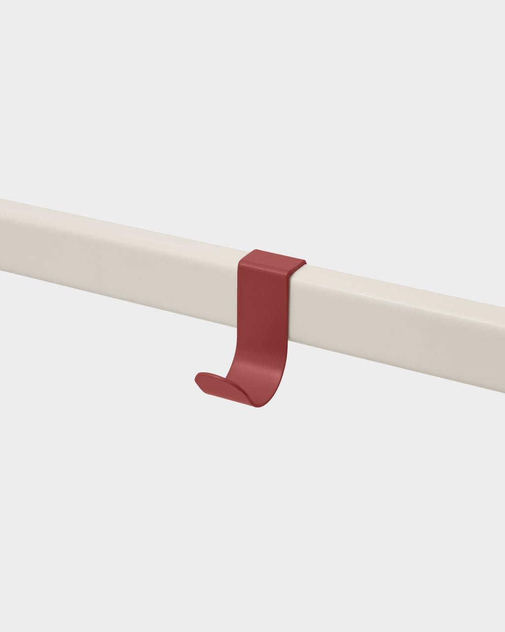 Burnin' Red Hook Mount clipped onto a cream rail in a studio packshot, angled view highlighting its curved J-shape
