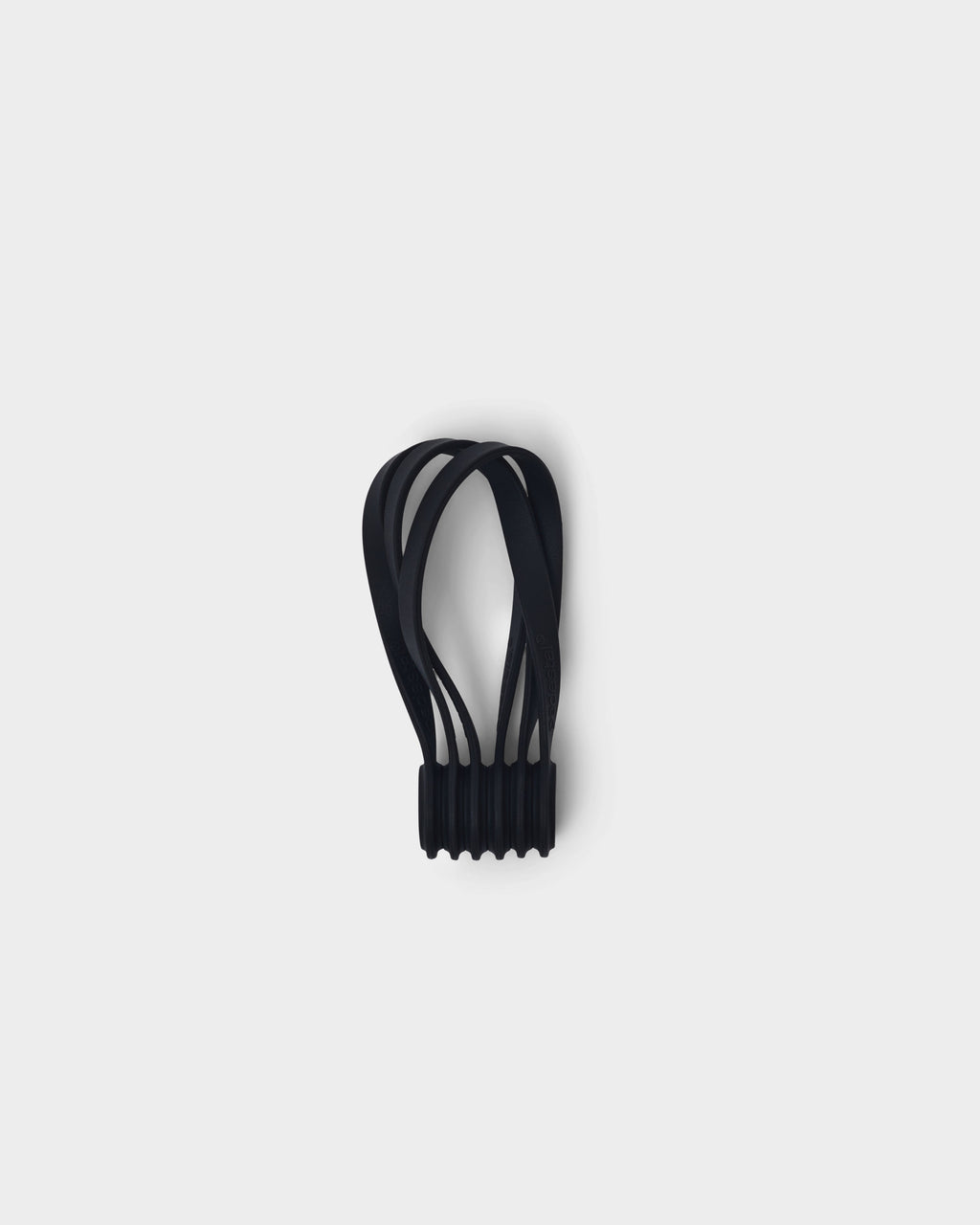 Set of charcoal Magnetic Cable Ties bundled in a ribbed holder, studio packshot on a plain light background