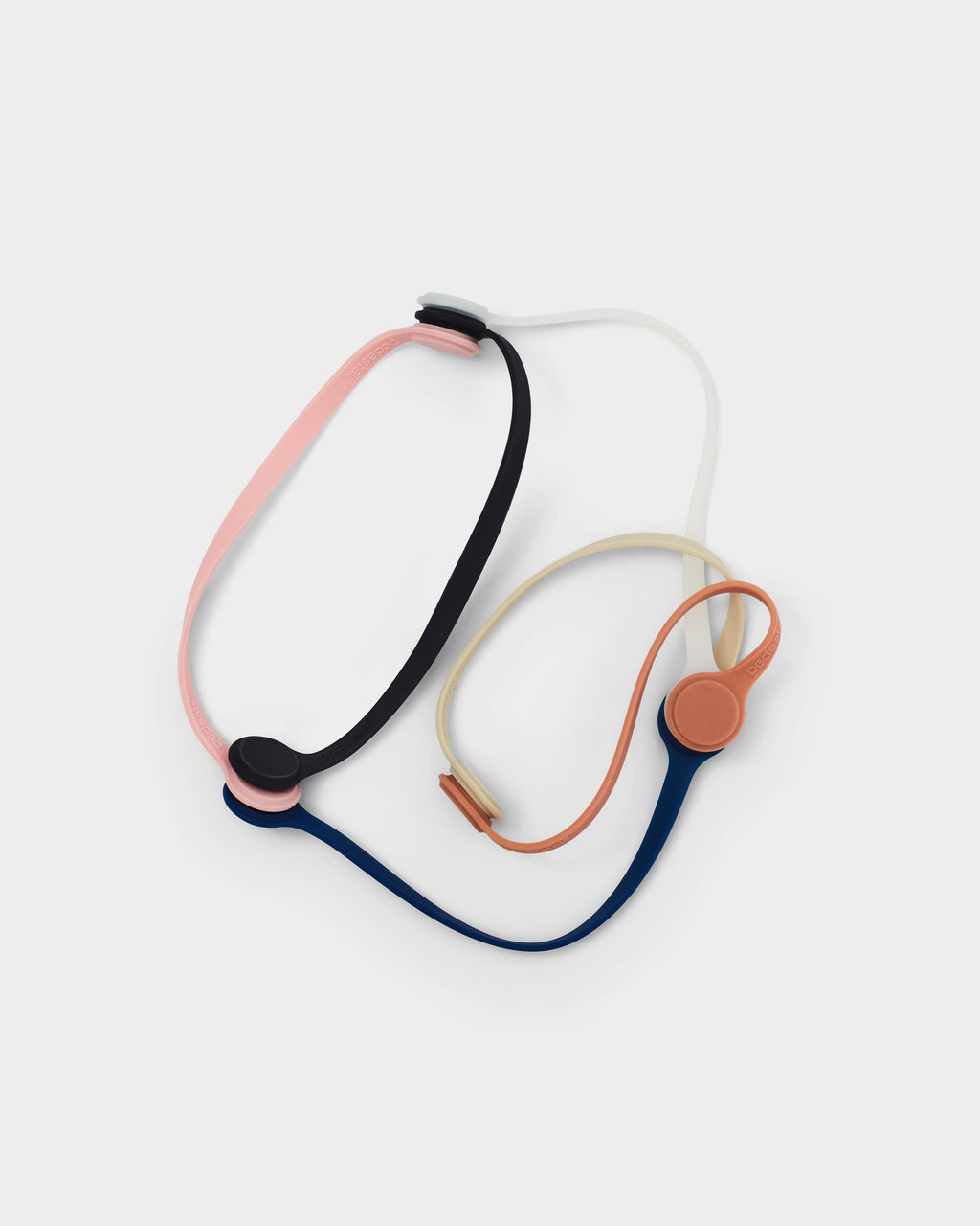 Ultra Marine Magnetic Cable Ties shown looped with pink, black, cream and orange versions in a studio packshot