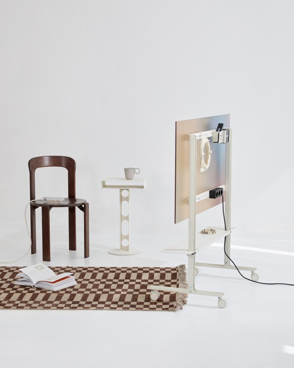 Pearl Magnetic Cable Ties bundling a white cord on a rolling studio cart, styled with wooden chair and checkered rug