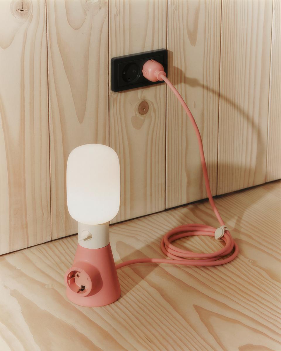 Pearl Magnetic Cable Tie bundling a coiled pink lamp cord on a wood floor beside a plug-in lamp in a sunlit room