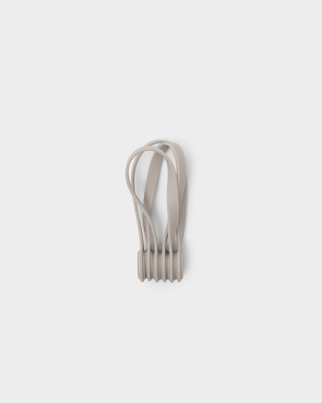 Set of Magnetic Cable Ties in Oat, studio packshot showing looped silicone straps stacked front-on with debossed logo