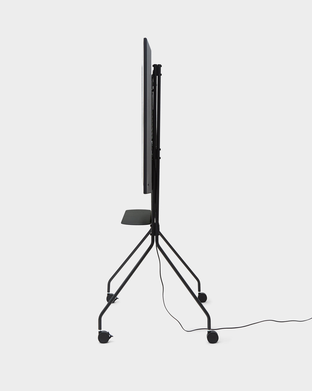 Side profile of the Moon PRO TV stand in Charcoal on a studio backdrop, showing slim frame, shelf, wheels and cable
