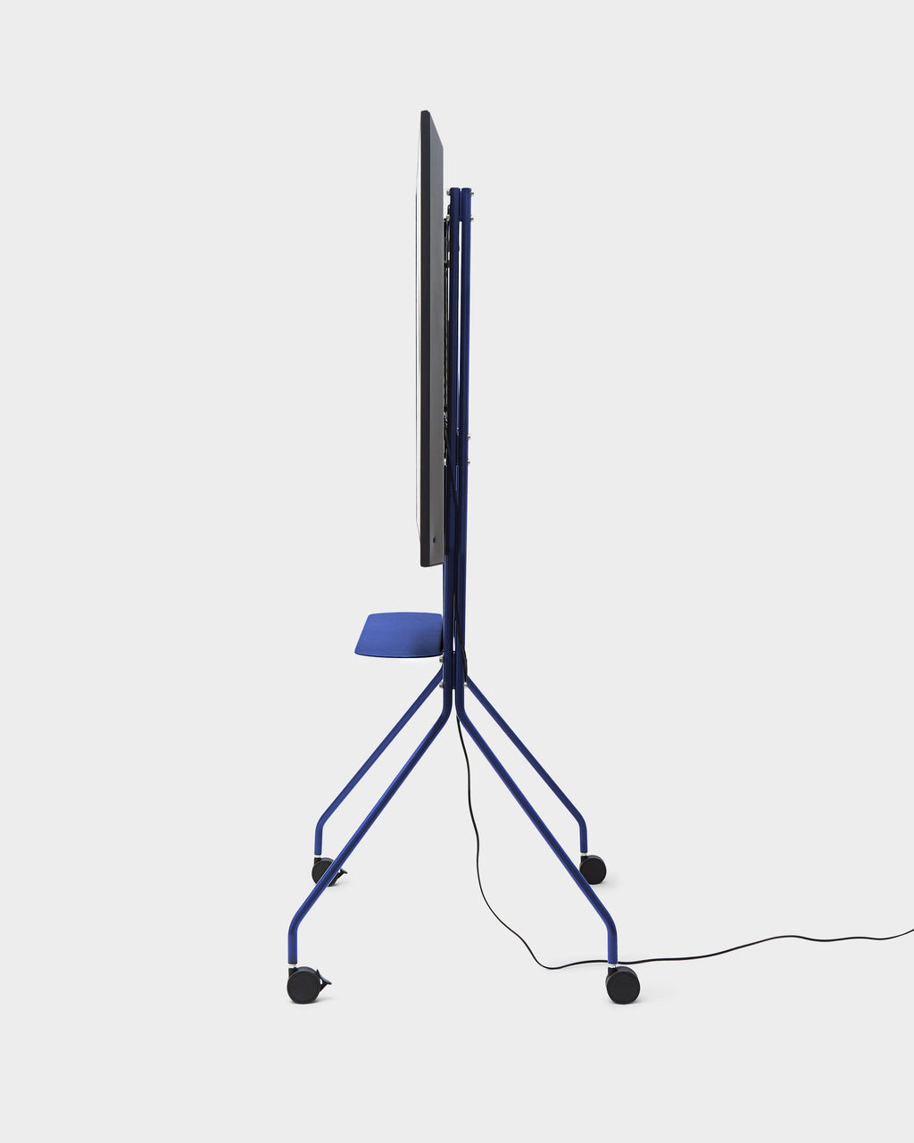 Side profile of Moon PRO TV stand in Ultra Marine with mounted screen, shelf, casters and cable on studio white