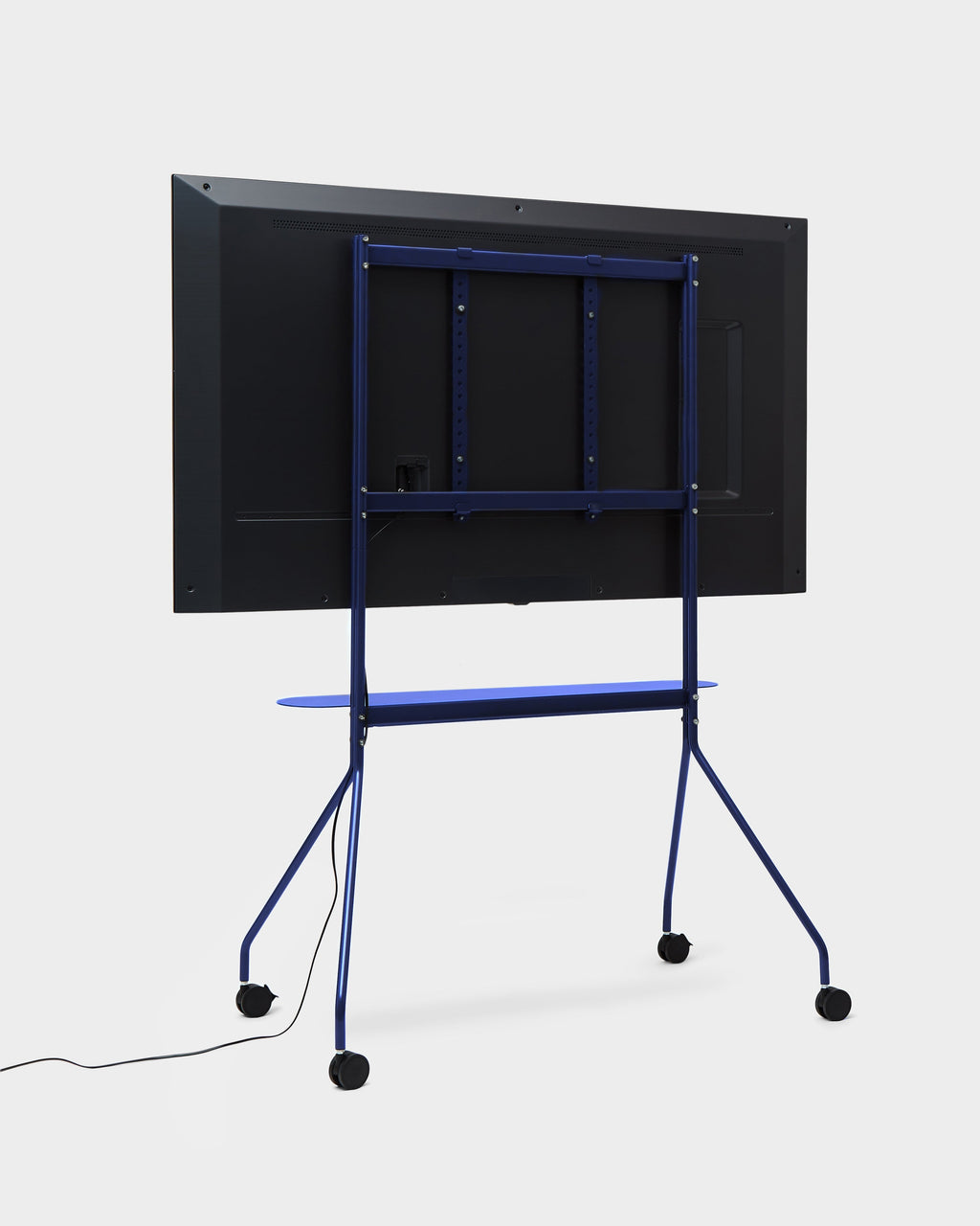 Rear angled studio view of Moon PRO TV stand in Ultra Marine with mounted flat screen, blue shelf and locking casters
