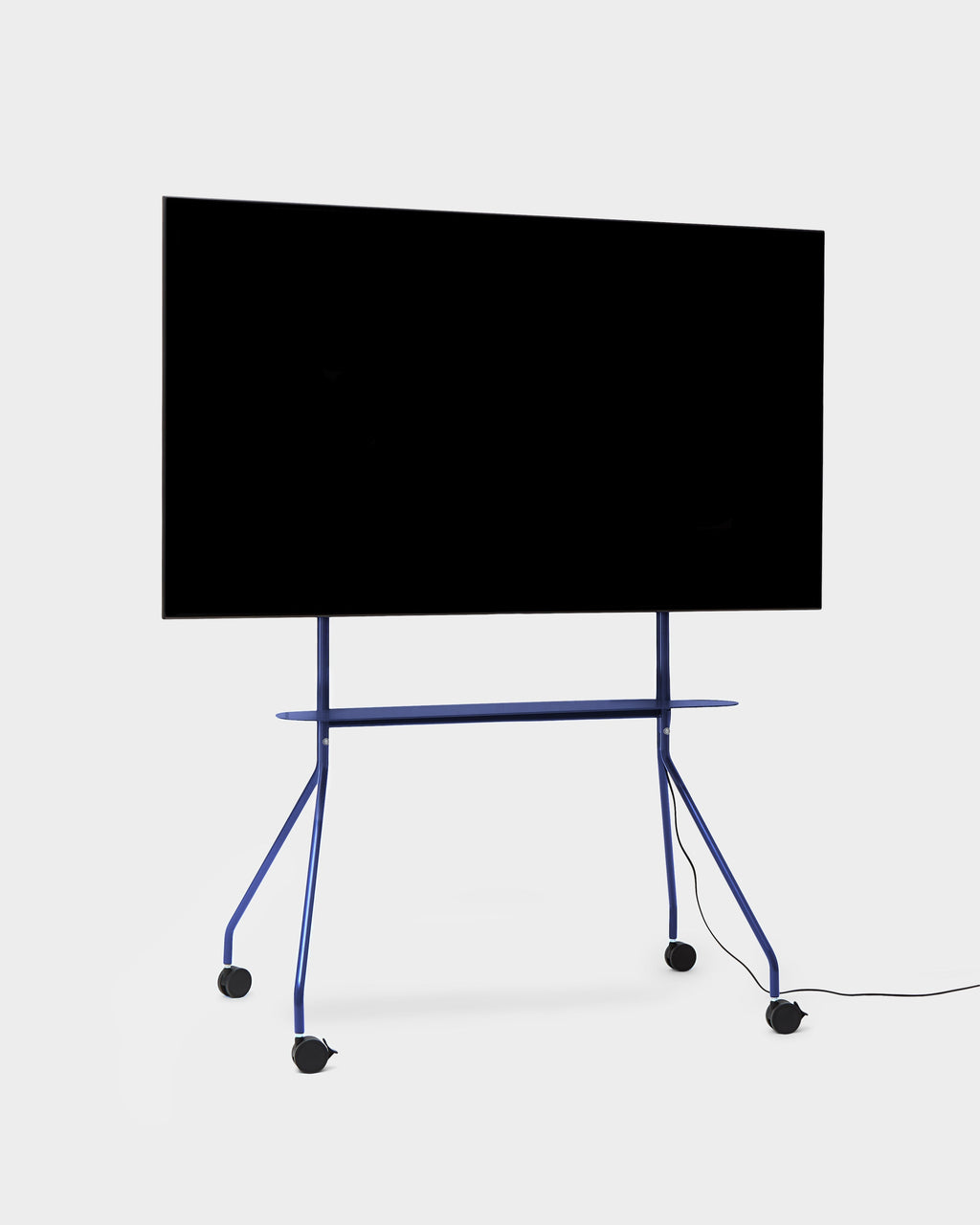 Moon PRO TV stand in Ultra Marine holding a large flat-screen TV, angled studio view showing shelf and locking casters