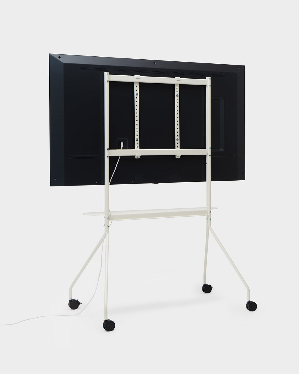 Rear view of Moon PRO TV stand in Pearl in a studio setting, mounted flat-screen TV, cable routing and locking casters