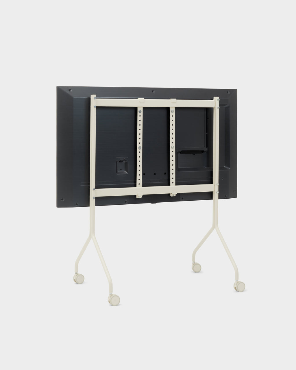 Rear view of Moon stand in Pearl on a studio backdrop, mounted TV with cream frame, angled legs and locking wheels