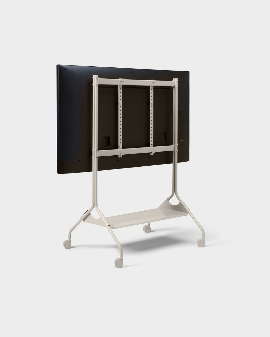 Rear three-quarter view of the Moon Tall stand in Oat with mounted display, shelf and wheels on white studio backdrop