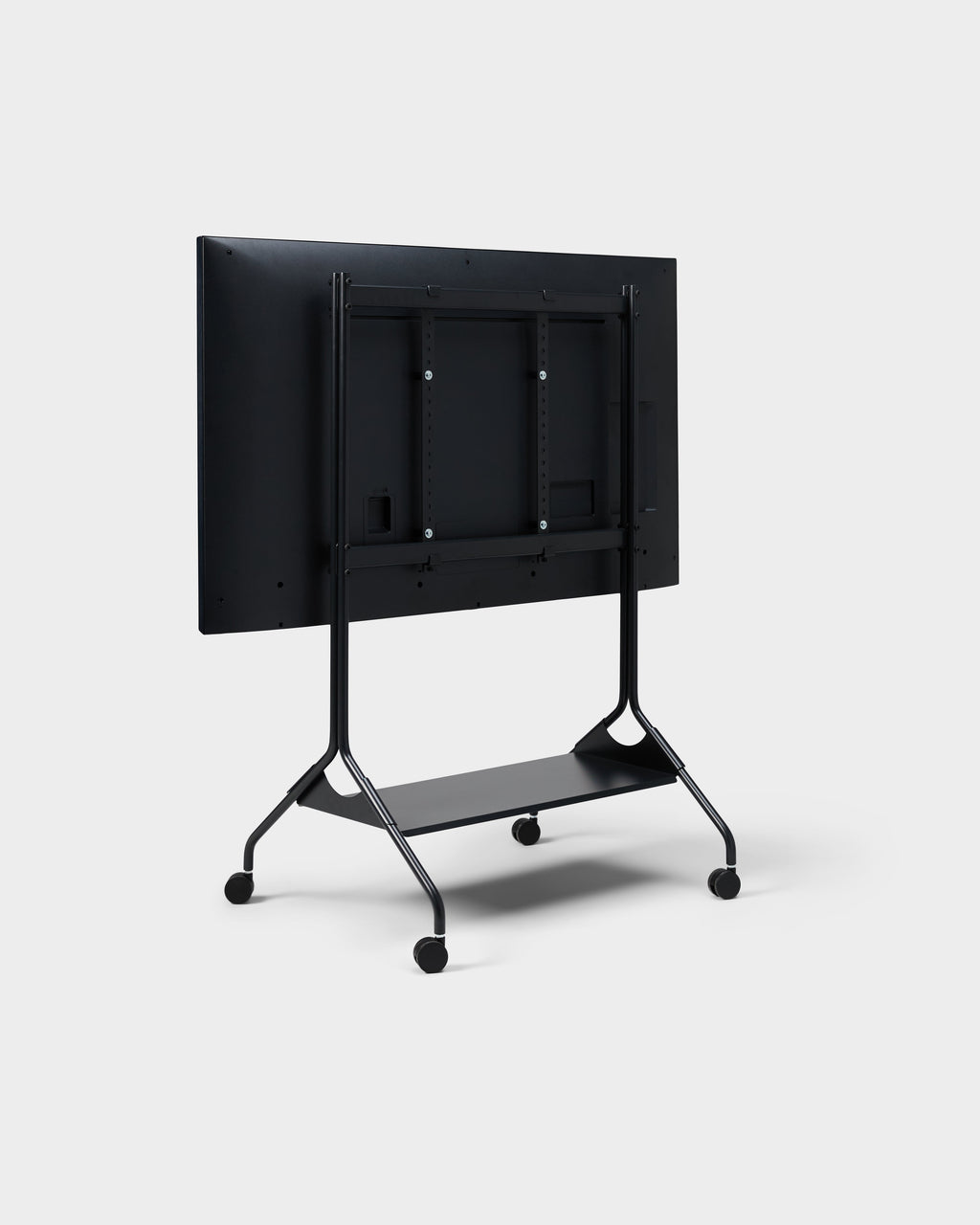 Rear three-quarter view of Moon Tall stand in Charcoal with mounted display, lower shelf and wheels, studio packshot