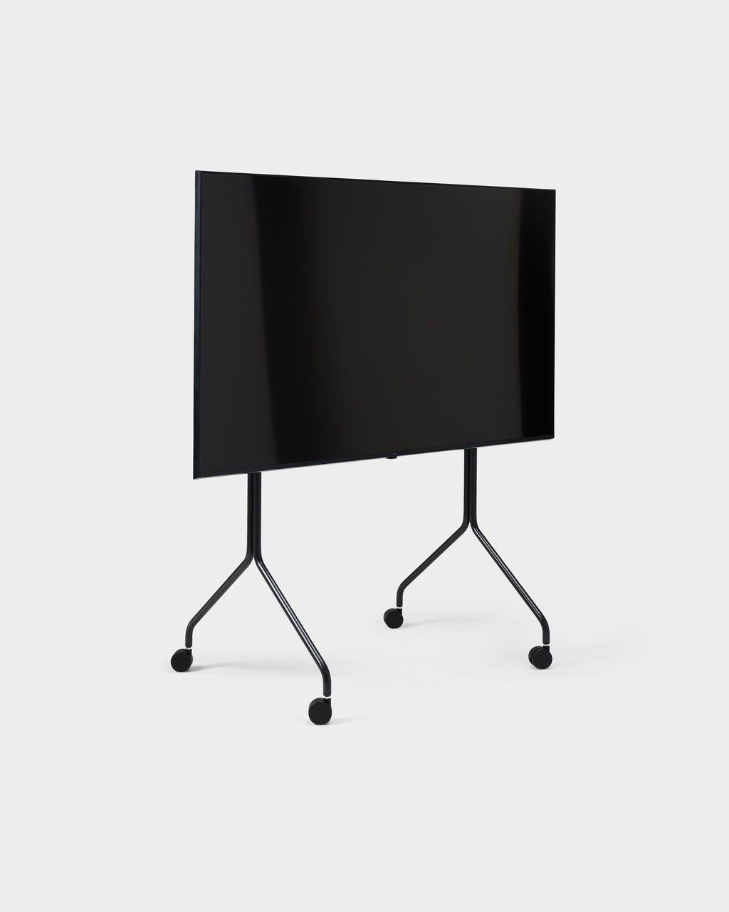 Moon Tall stand in Charcoal shown at an angle in a studio packshot, holding a large TV on slim legs with casters