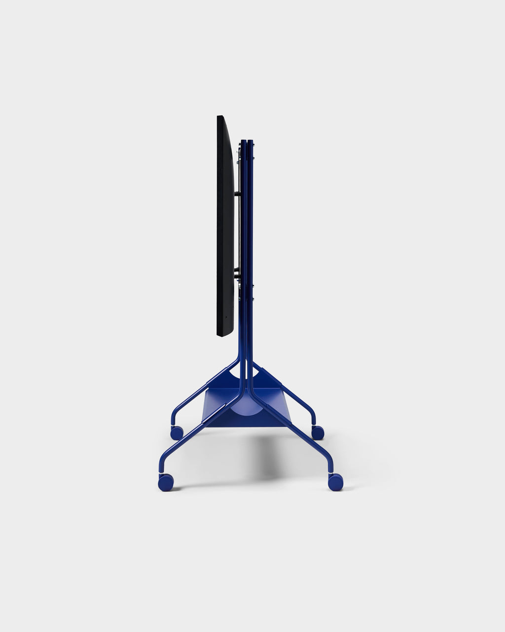 Side profile of Moon Tall stand in Ultra Marine with mounted TV, showing slim tubular frame and wheeled base on studio white
