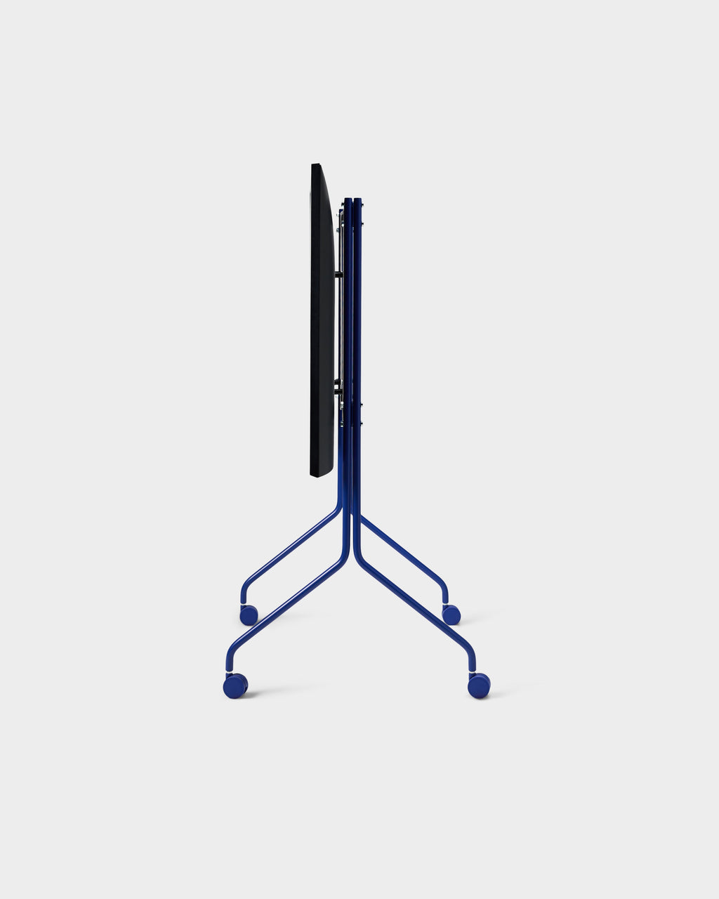 Side profile of Moon Tall TV stand in Ultra Marine, showing folded blue tubular frame and four casters on a studio backdrop