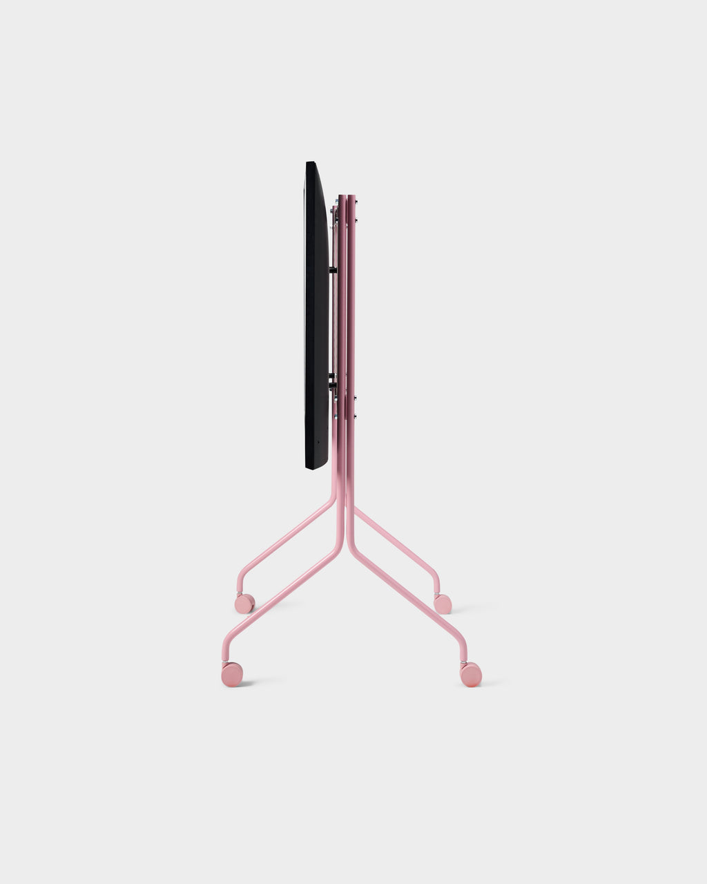 Side profile of the Moon Tall stand in Bubble Gum pink, folded flat on wheeled legs against a studio backdrop