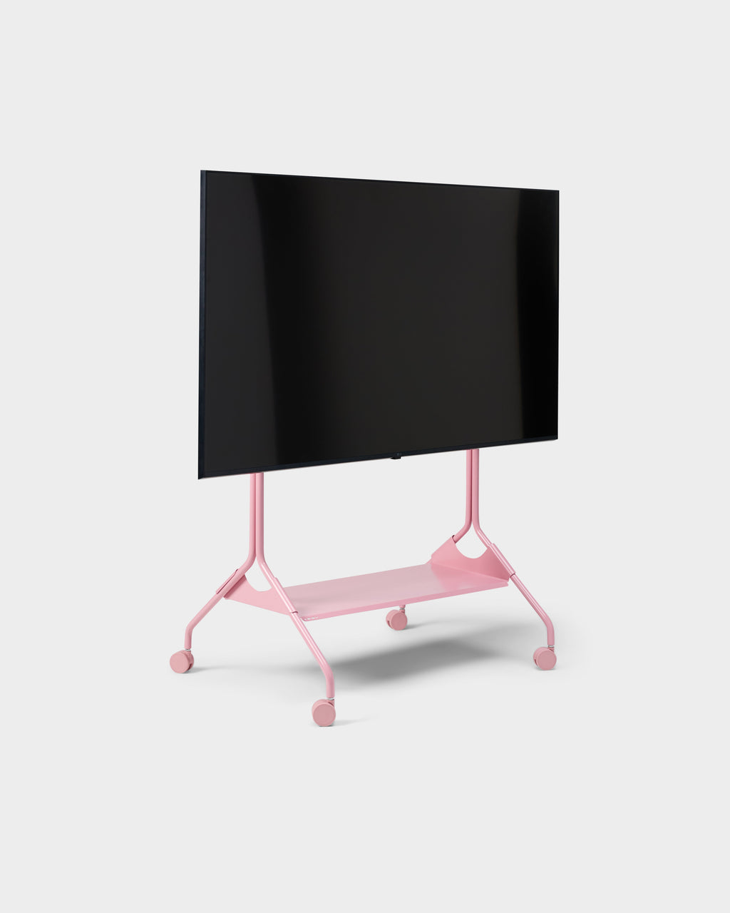 Moon Tall stand in Bubble Gum pink shown at an angle in studio with mounted flat-screen TV, storage shelf and casters