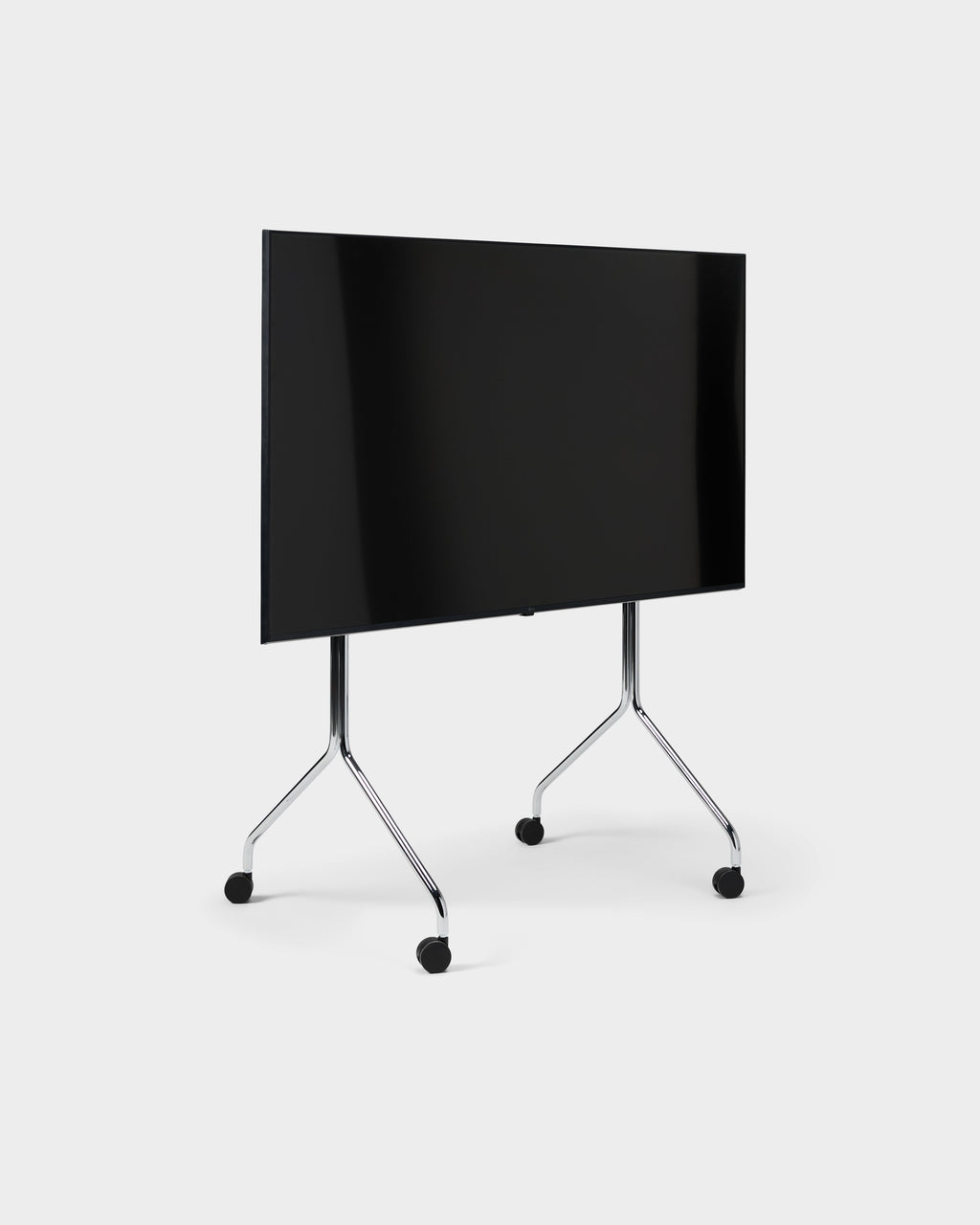 Moon Tall stand in chrome shown at an angle in a studio packshot, holding a large black TV on four caster wheels