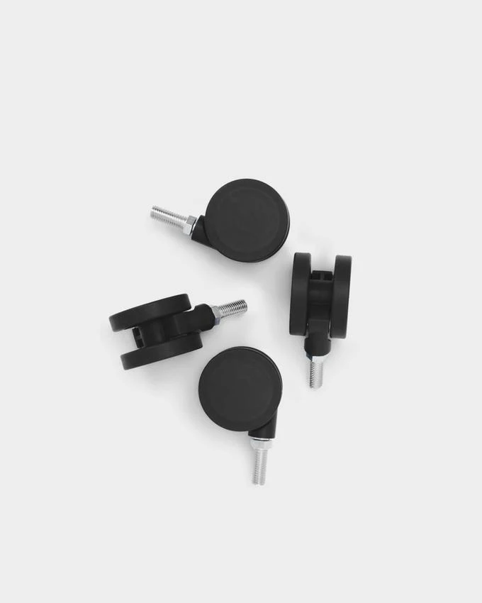 Set of four charcoal Wheels casters with threaded metal stems, arranged on a light grey studio background